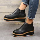 Schwarze Plateau-Stiefeletten mit Reißverschluss, kombiniert mit blauen Jeans. Modische Damen-Schuhe, ideal für trendige Herbst- und Winterlooks.