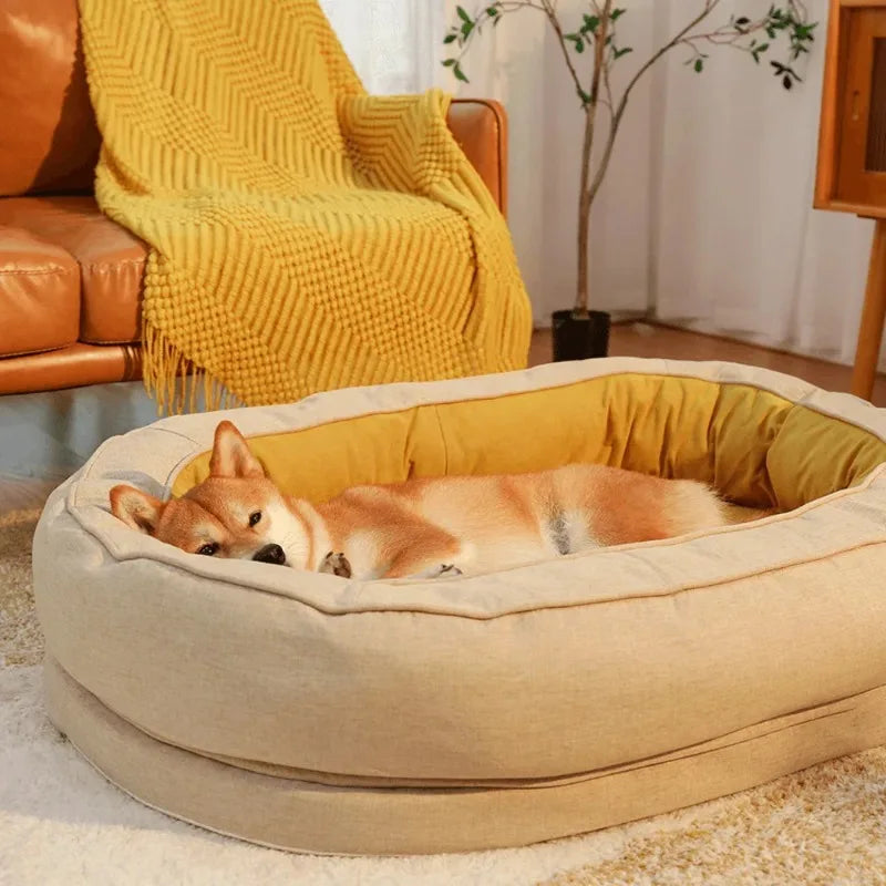 Hund schläft in beigem Hundebett aus Stoff vor Ledersofa mit gelber Decke im Wohnzimmer.