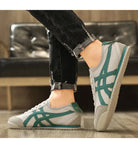 Graue und grüne Sneaker im Retro-Stil, ideal für Freizeit und Sport. Bequeme Turnschuhe mit trendigem Design und rutschfester Sohle.