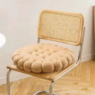 Beiger, runder Sitzkissen auf Holzstuhl mit Rattanlehne, gemütlich, modern, Wohnzimmer-Dekor.