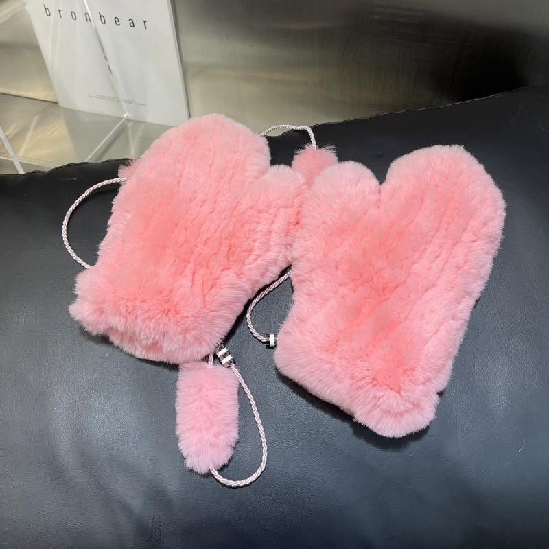 Rosa Plüsch-Fäustlinge auf schwarzem Hintergrund, ideal für Wintermode. Flauschige Handschuhe, warm und stilvoll, perfekt für kalte Tage.