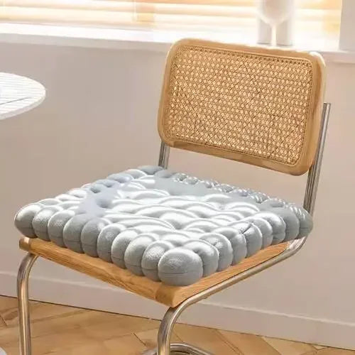 Graues Gel-Sitzkissen auf Holzstuhl, ergonomisch, rutschfest, für Bürostühle geeignet.