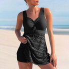 Frau im schwarzen Badeanzug mit Muster am Strand, Sommermode, Bademode für Damen.