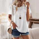 Elegantes Damen-Outfit: Weiße Spitzenbluse mit kurzen Ärmeln, kombiniert mit lässigen Jeansshorts. Perfekt für Sommermode und Freizeitlooks.