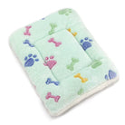Weiches Hundebett, grün, mit bunten Pfoten- und Knochenmotiven, gemütlich, waschbar.