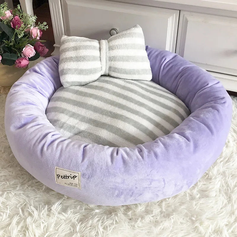 Lila Hundebett aus Plüsch mit gestreiftem Kissen, rund, gemütlich, für kleine Hunde.