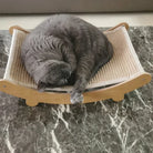 Graue Katze schläft auf Katzenbett aus Holz und Sisal auf Marmortisch. Haustiermöbel, Katzenzubehör.