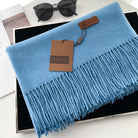 Luxuriöser blauer Schal mit Fransen, aus weichem Material, ideal für stilvolle Wintermode. Perfektes Accessoire für Damen und Herren.
