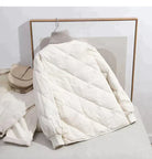 Weiße Steppjacke mit hohem Kragen, modisch und warm, ideal für den Winter. Perfekt kombinierbar mit urbanem Stil. Hochwertige Wintermode.
