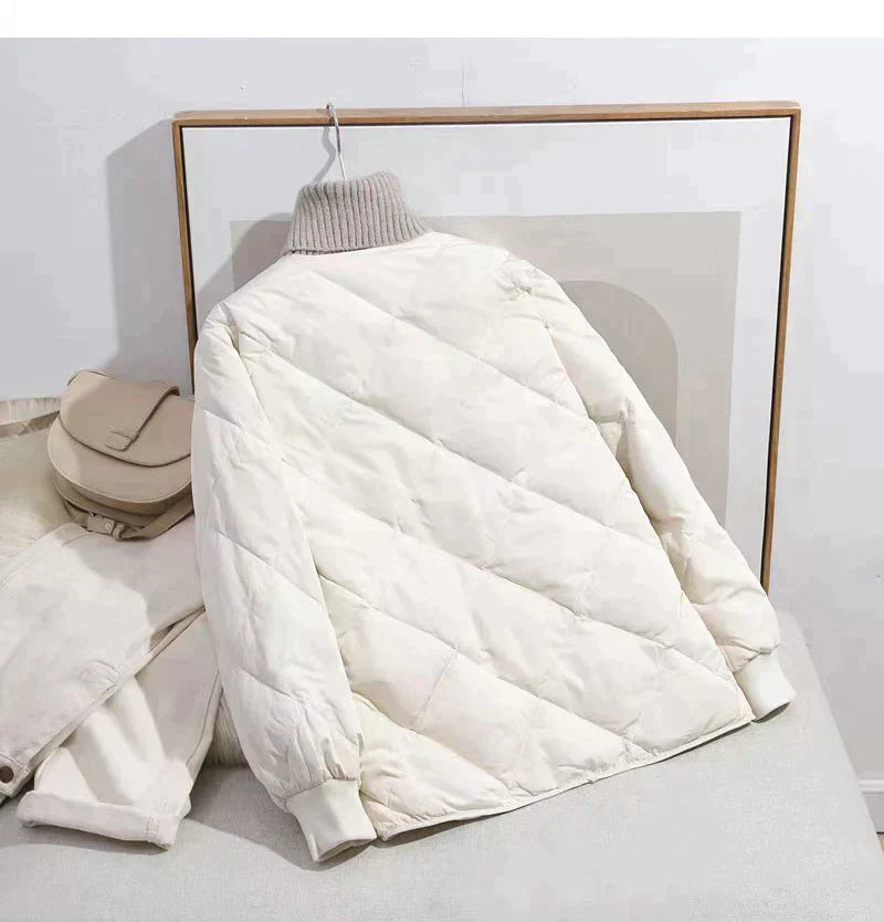 Weiße Steppjacke mit hohem Kragen, modisch und warm, ideal für den Winter. Perfekt kombinierbar mit urbanem Stil. Hochwertige Wintermode.