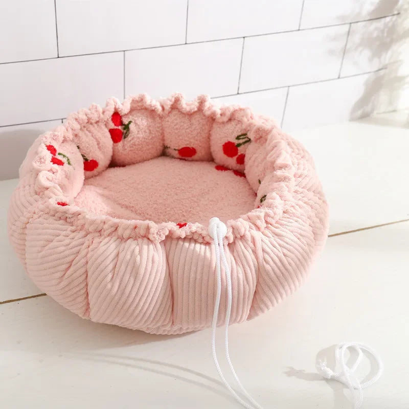 Rosa Haustierbett aus Plüsch mit Kirschmuster, rund, gemütlich, für Katzen und kleine Hunde.