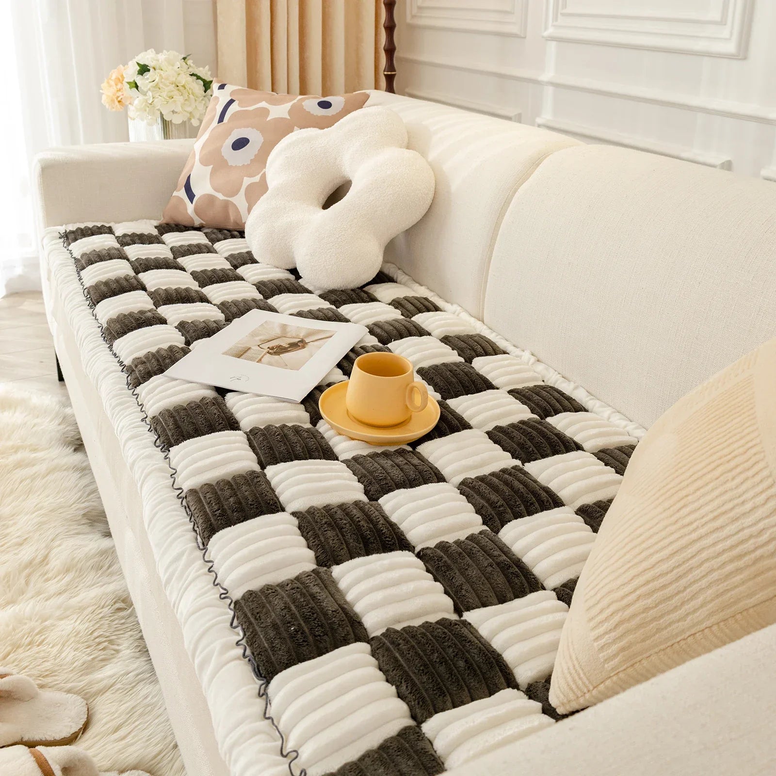 Beige Sofa mit kariertem Überwurf, Kissen und gelber Tasse, modernes Wohnzimmerdekor.