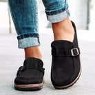 Schwarze Mokassins mit Schnalle, kombiniert mit hochgekrempelten Jeans. Bequeme, stilvolle Schuhe für Freizeit und Alltag.