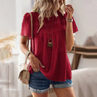 Damenmode: Rote Bluse mit Spitzenmuster, kombiniert mit Jeansshorts. Sommeroutfit, lässig, stilvoll, ideal für Freizeit und Alltag.