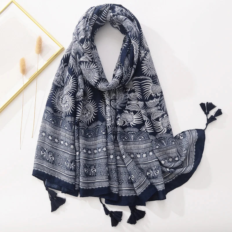 Dunkelblauer Schal mit weißem, floralem Muster und Quasten, ideal für Damenmode. Perfekt als Accessoire für Herbst und Winter.