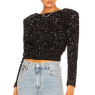 Schwarzes Pailletten-Oberteil mit langen Ärmeln, kombiniert mit hellblauen Jeans. Perfekt für glamouröse Abendmode und Partys.