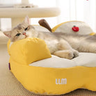 Katze auf gelbem, weichem Katzenbett mit Apfel-Design, gemütlich und entspannend.