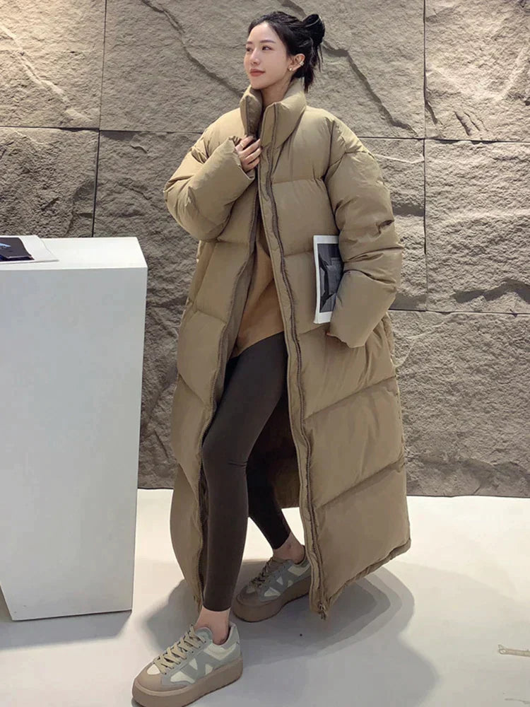 Langer, beiger Daunenmantel für Damen, ideal für Wintermode. Stilvoll und warm, perfekt für kalte Tage. Trendige Damenbekleidung.