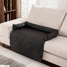 Schwarzer, gesteppter Sofaschutz aus Polyester auf beigem Sofa, ideal für Haustiere.