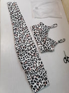 Leopard-Print Sport-BH und Leggings-Set auf weißem Hintergrund. Modisches Fitness-Outfit für Damen, ideal für Yoga und Workout.