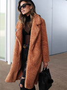 Frau in modischem, braunem Teddy-Mantel, schwarze Sonnenbrille, zerrissene Jeans und schwarzer Tasche. Trendige Herbst-Winter-Mode 2023.