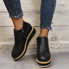Schwarze Plateau-Stiefeletten mit Reißverschluss, kombiniert mit modischen, ausgefransten Jeans. Trendige Damen-Schuhe für Herbst und Winter.