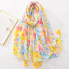 Bunter Blumenschal aus leichtem Stoff mit gelben Quasten, ideal für Frühling und Sommer. Perfektes Accessoire für modische Outfits.
