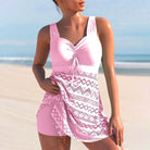 Frau im rosa Badeanzug mit Spitzenmuster am Strand, Sommermode, Strandkleidung.