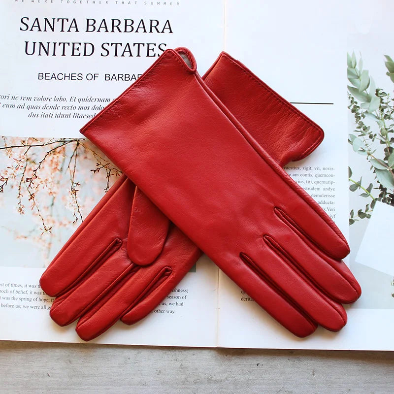 Rote Lederhandschuhe auf offenem Buch, stilvoll und elegant. Perfekt für Herbstmode, Damenaccessoires, hochwertige Materialien, modische Akzente.