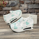 Weiße Damen-Sneaker mit grüner Spitze, Plateau-Sohle und floralem Design. Modische Freizeitschuhe, ideal für trendbewusste Frauen.
