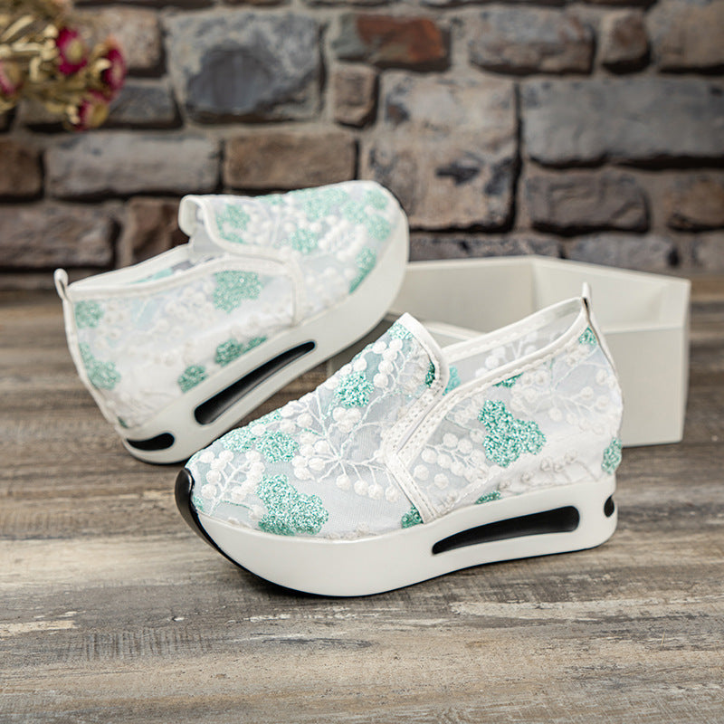 Weiße Damen-Sneaker mit grüner Spitze, Plateau-Sohle und floralem Design. Modische Freizeitschuhe, ideal für trendbewusste Frauen.