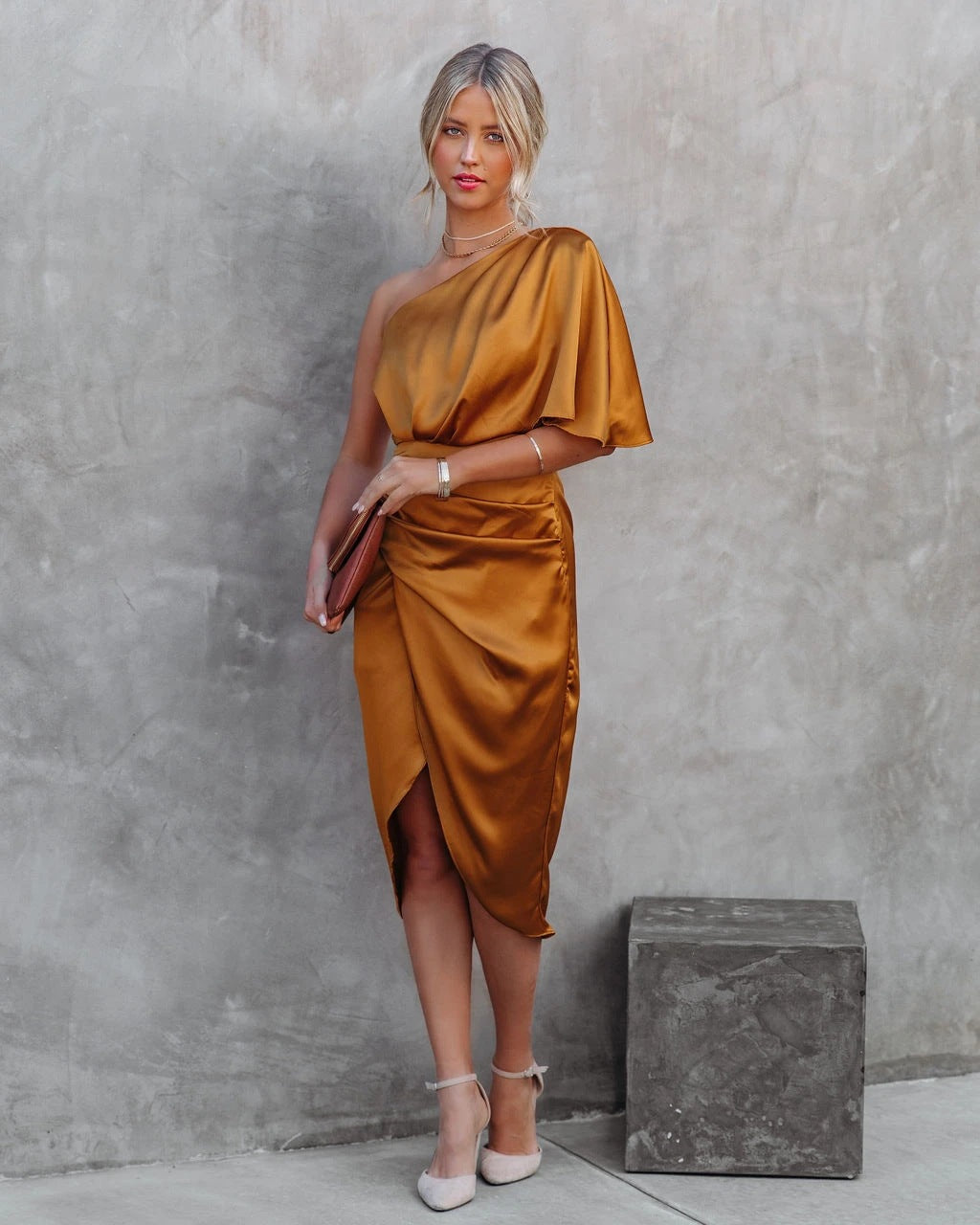 Elegantes, einseitiges, goldenes Satinkleid, ideal für Abendveranstaltungen. Perfekt kombiniert mit Clutch und High Heels für stilvolle Auftritte.