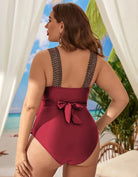Frau im roten Badeanzug mit Schleife, Strandhintergrund, Sommermode, Plus-Size-Bademode.