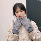 Damen in grauen Winterhandschuhen und beiger Steppjacke. Modische, warme Accessoires für kalte Tage. Perfekt für stilvolle Winteroutfits.