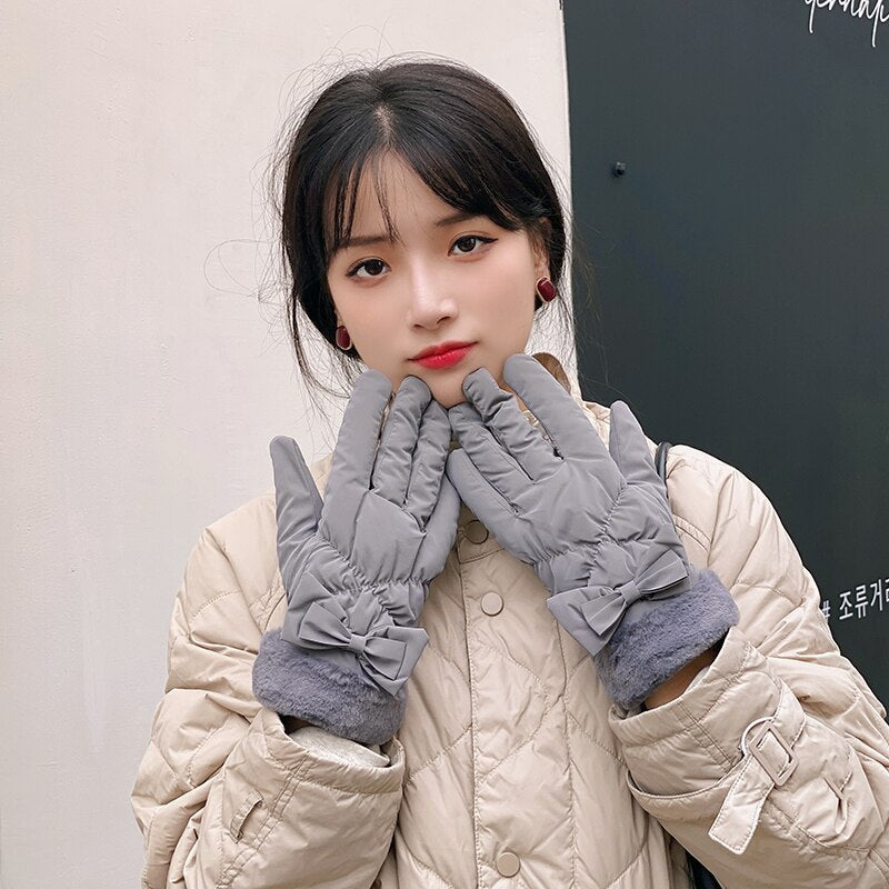 Damen in grauen Winterhandschuhen und beiger Steppjacke. Modische, warme Accessoires für kalte Tage. Perfekt für stilvolle Winteroutfits.