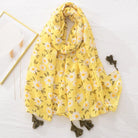Gelber Schal mit Gänseblümchenmuster und Quasten, ideal für Frühling und Sommer. Modisches Accessoire, leicht und vielseitig tragbar.