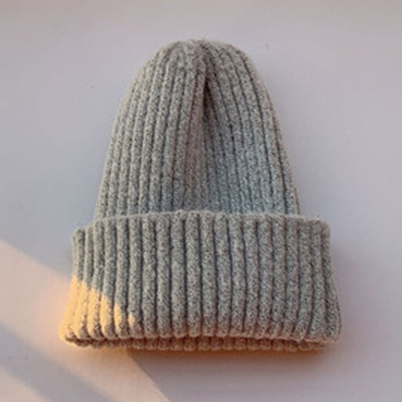 Graue Strickmütze aus weichem, geripptem Material, ideal für Wintermode. Perfekt für Damen und Herren, warm und stilvoll.