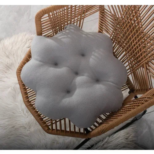 Graues, blumenförmiges Sitzkissen auf Rattanstuhl, modernes Design, Wohnzimmerdekoration.