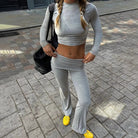 Graues, langärmeliges Crop-Top und passende Hose, sportlich und modisch, ideal für Fitness und Freizeit. Perfekt kombiniert mit gelben Sneakern.