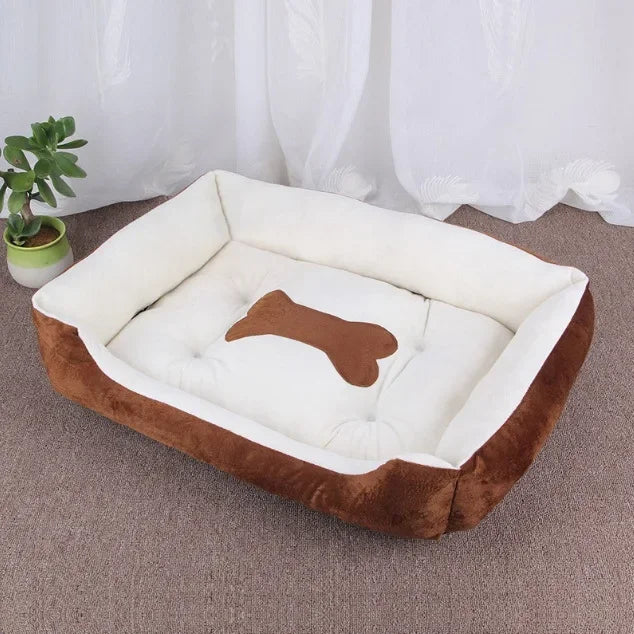 Braunes Hundebett aus Plüsch mit Knochenmotiv, rechteckig, gemütlich, auf Teppichboden.