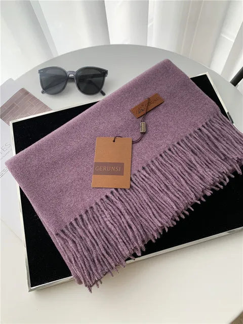 Lila Kaschmirschal mit Fransen auf schwarzem Hintergrund, stilvoll und elegant. Perfekt für Herbstmode. Hochwertige Accessoires, modische Schals.