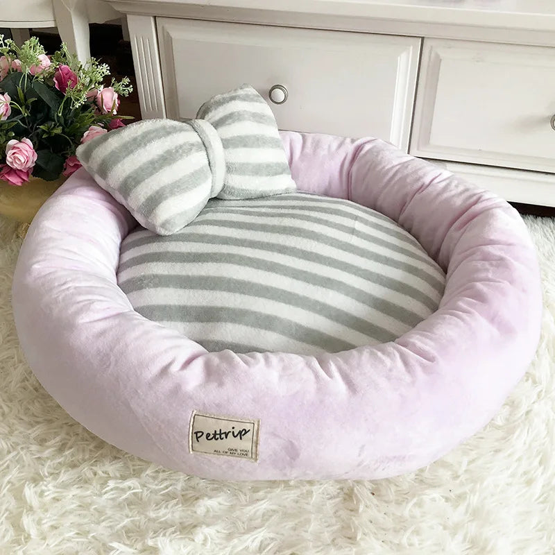 Rundes, gestreiftes Hundebett in Grau und Rosa, Plüschmaterial, gemütlich, mit Schleifen-Design.