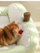 Katzenbett grün-weiß mit Spielzeug, weiches Haustierbett, gemütlicher Schlafplatz für Katzen.