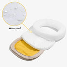 Wasserdichter weißer Toilettensitzbezug aus Kunststoff mit gelbem Innenfutter.