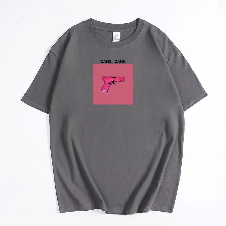 Graues T-Shirt mit pinkem Pistolen-Print und "Gang Gang"-Schriftzug. Trendige Streetwear, ideal für urbane Mode und lässigen Stil.
