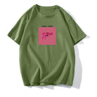 Grünes T-Shirt mit pinkem Pistolen-Print und "Gang Gang"-Schriftzug. Trendige Streetwear, lässiger Stil, hochwertiger Baumwollstoff.