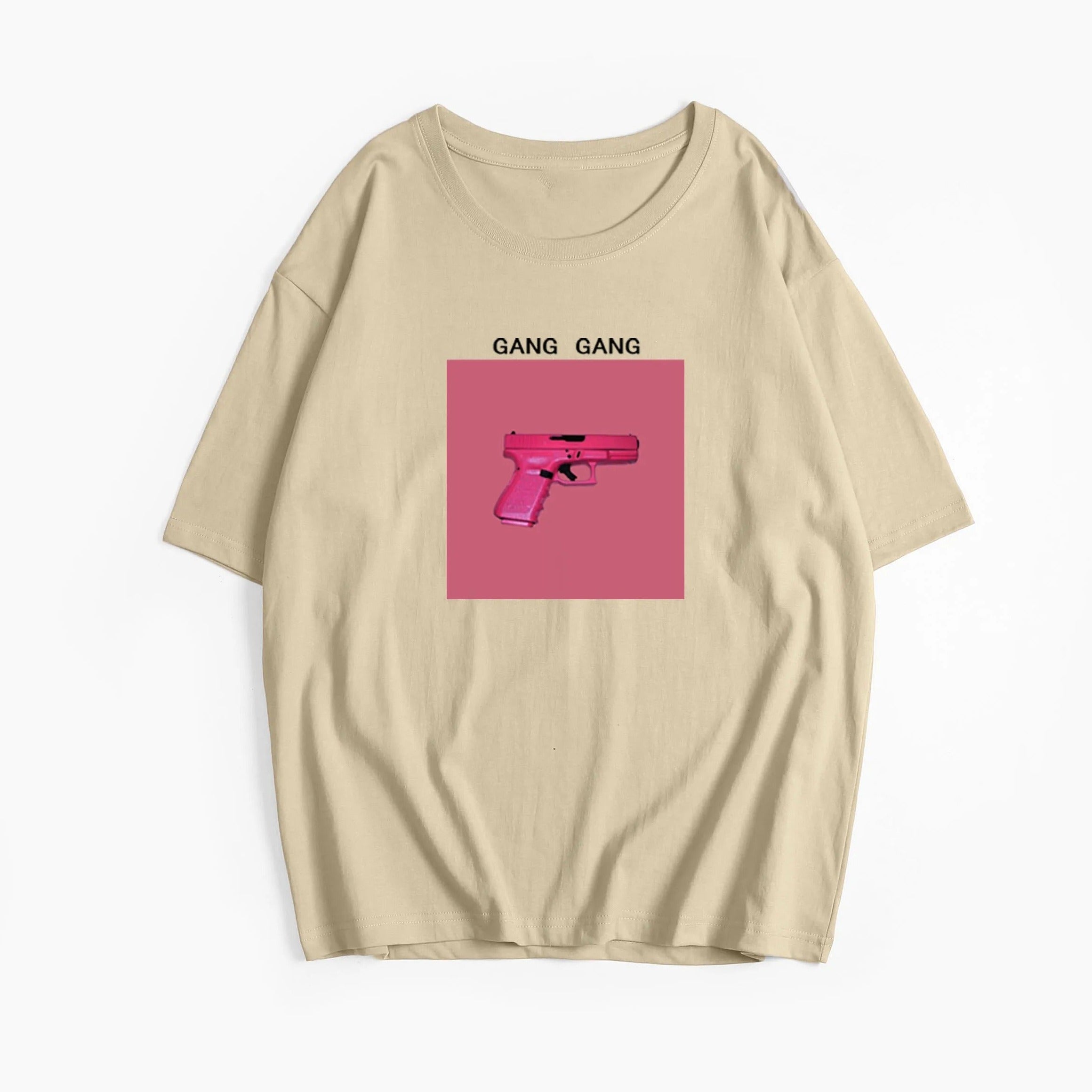 Beiges T-Shirt mit pinkem Pistolen-Print und "Gang Gang"-Schriftzug. Trendige Streetwear, ideal für urbane Mode und lässigen Stil.
