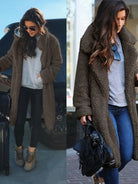 Frau im braunen Teddy-Mantel, grauem Pullover und Jeans, trägt Sonnenbrille und schwarze Tasche. Modetrend, Wintermode, lässiger Look.