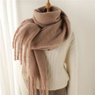 Damenpullover mit Zopfmuster in Creme, kombiniert mit einem weichen, braunen Schal. Perfekt für Herbstmode, gemütlich und stilvoll.