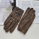 Braune Lederhandschuhe mit perforiertem Design auf weißem Hintergrund. Elegante Accessoires, ideal für stilvolle Herbst- und Wintermode.